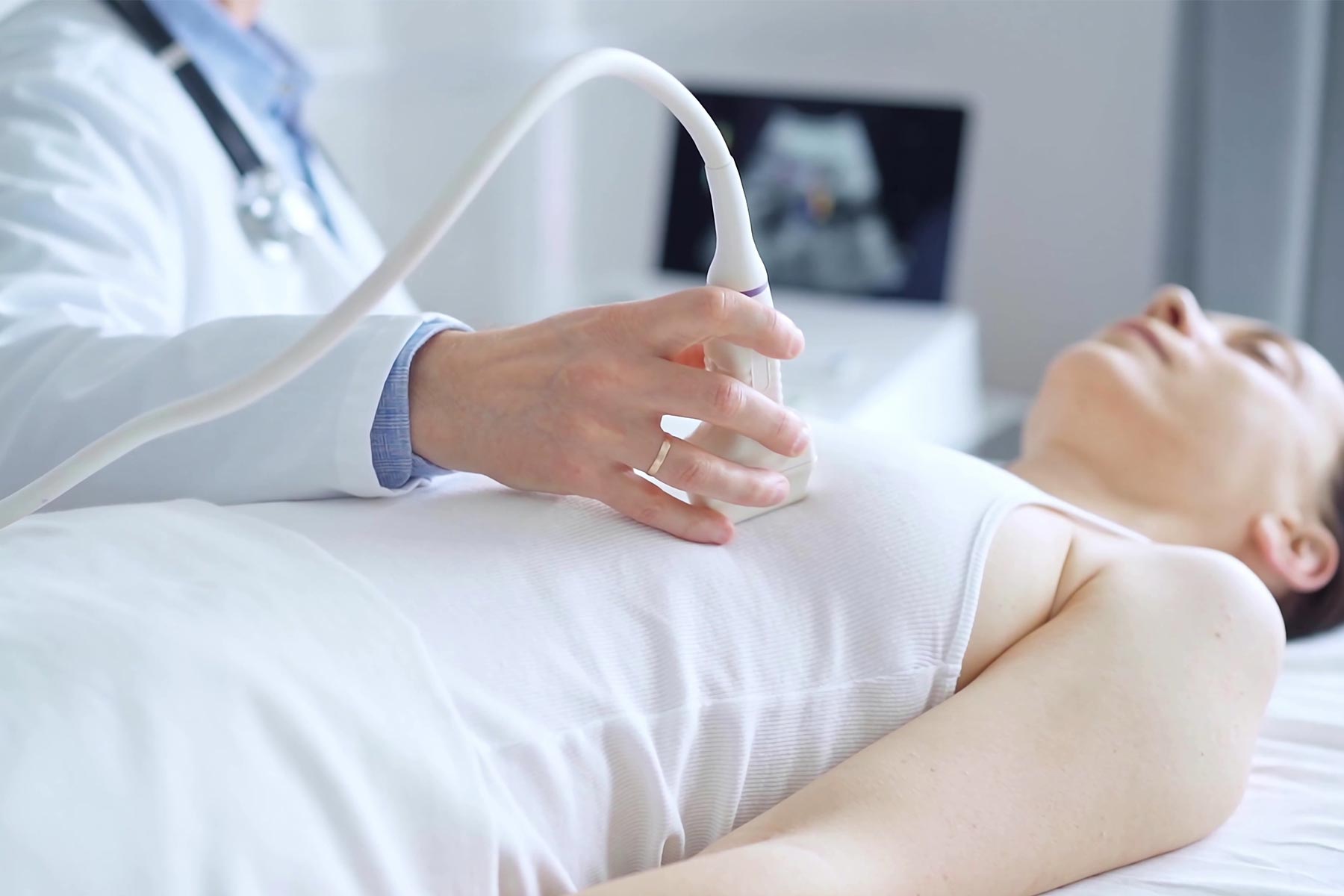 A female patient undergoes a breast ultrasound scan in a clinic setting A female patient undergoes a breast ultrasound scan in a clinic setting