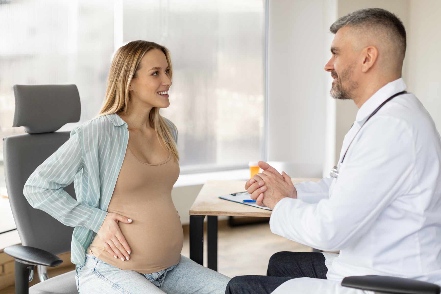 A pregnant woman at an appointment with her obstetrician or perinatologist